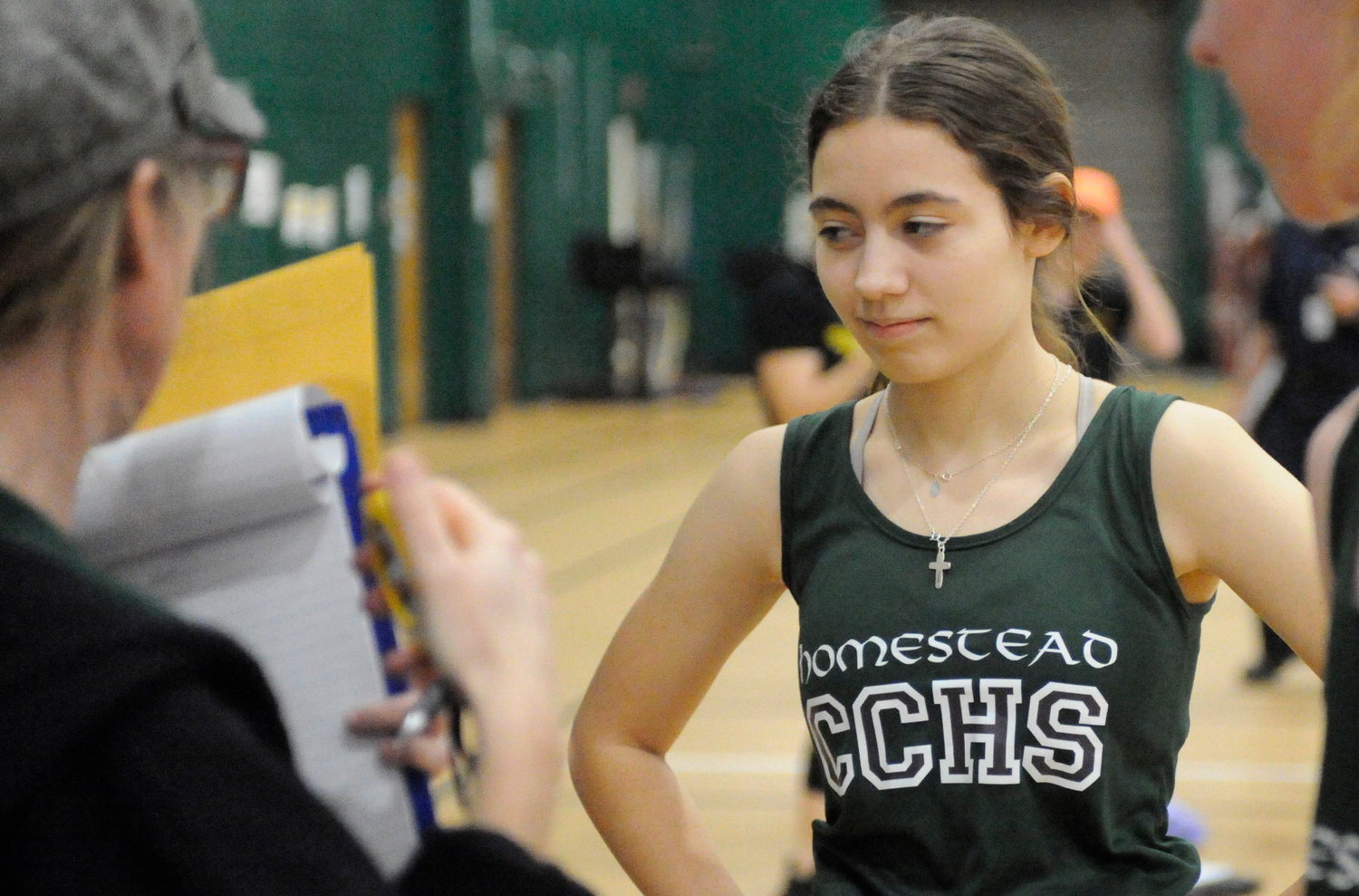 Natalie Westergreen, a sophomore, runs the 55-meter and 300-meter races. She is pictured checking her times with Coach Shannon.